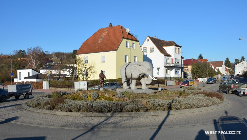 Granitskulptur eines Elefanten vor einem Pflug auf dem Verkehrskreisel in der Rosenhofstraße in Enkenbach.