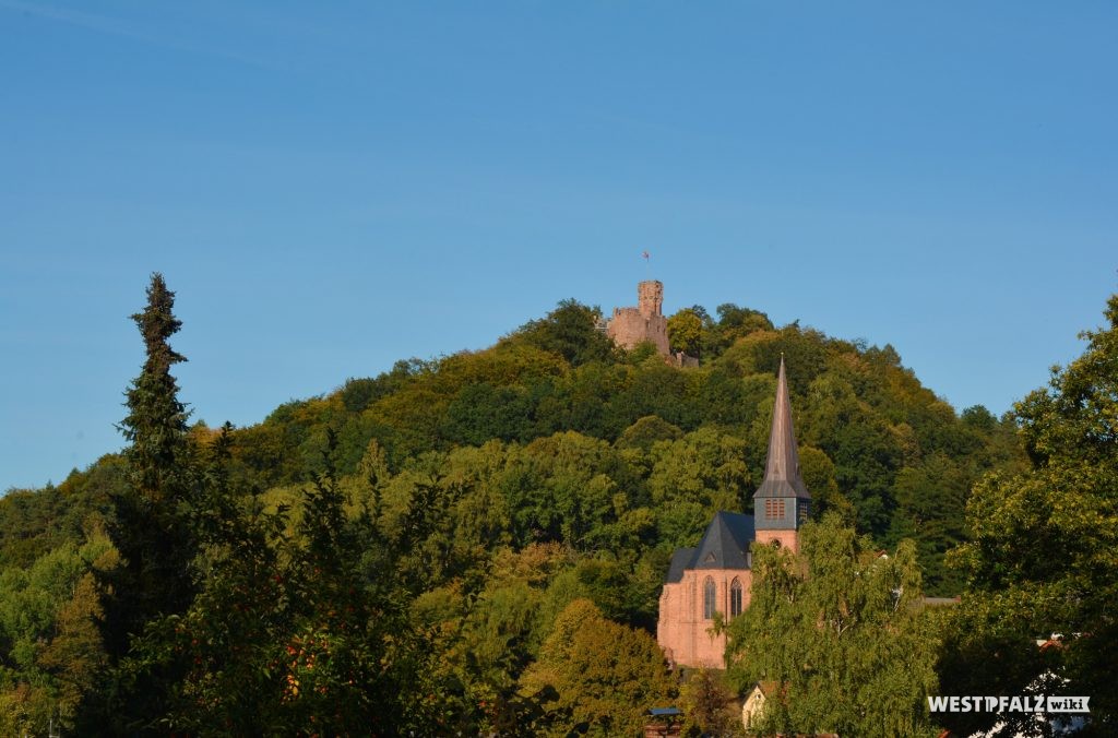 Westansicht der Rochuskirche in Kaiserslautern Hohenecken. Im Hintergund die Ruine der Burg Hohenecken auf dem Schlossberg.