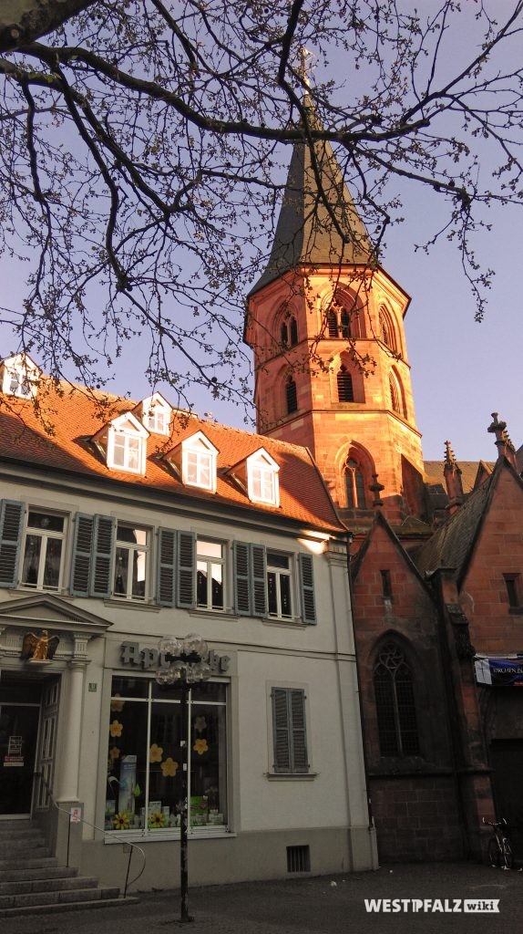 Blick auf den Kirchturm der Stiftskirche in Kaiserslautern. Links daneben ist die Adler-Apotheke.
