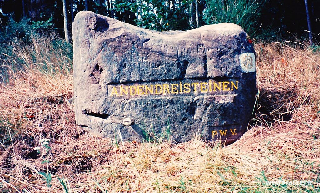 Das Foto zeigt Ritterstein Nr. 85 mit der Inschrift "An Den Drei Steinen" und "PWV" (Pfälzerwald-Verein).
