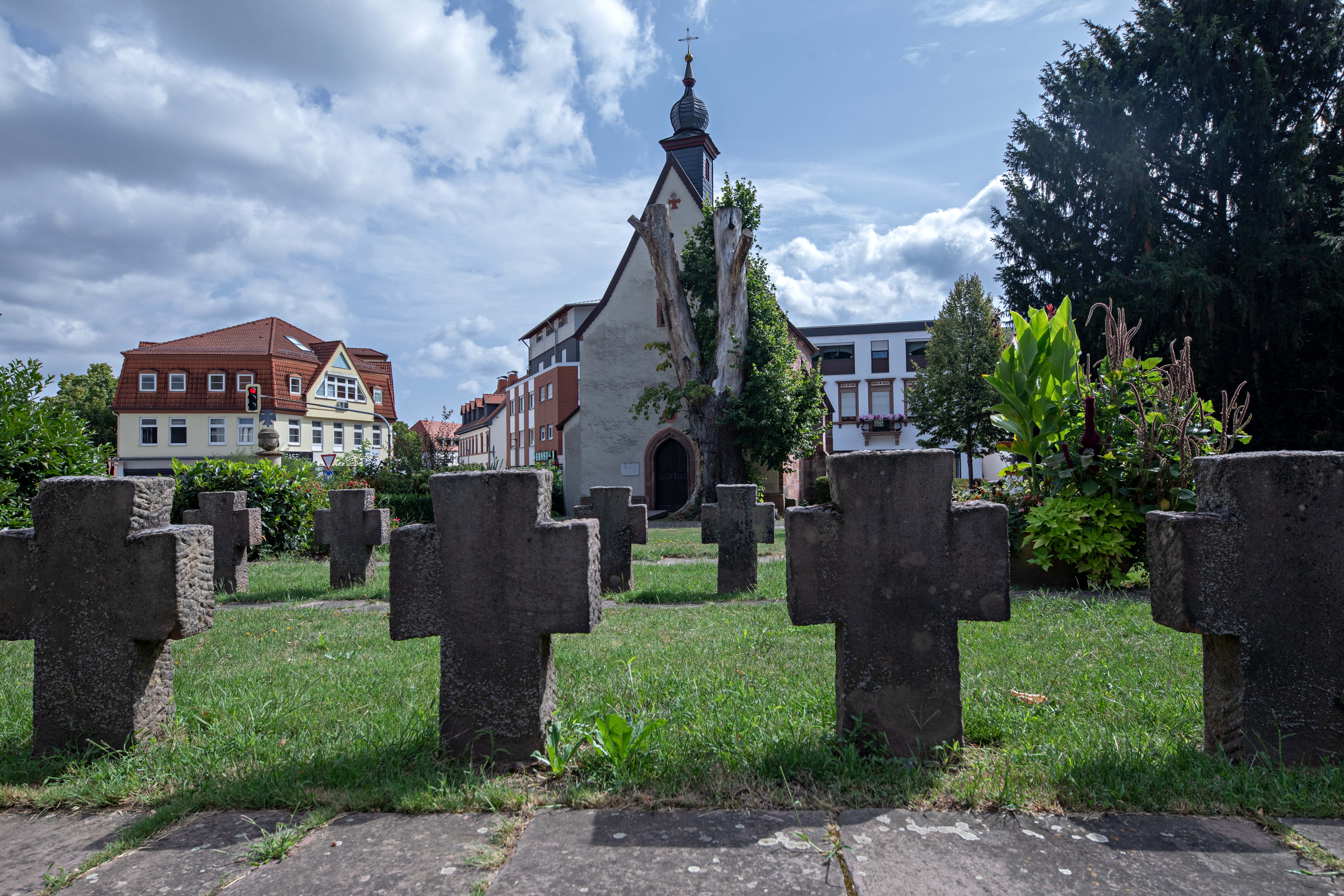 Blick in östliche Richtung auf die Alte Kapelle in Landstuhl. Im Vordergrund stehen Kreuze von im Zweiten Weltkrieg gefallener Soldaten