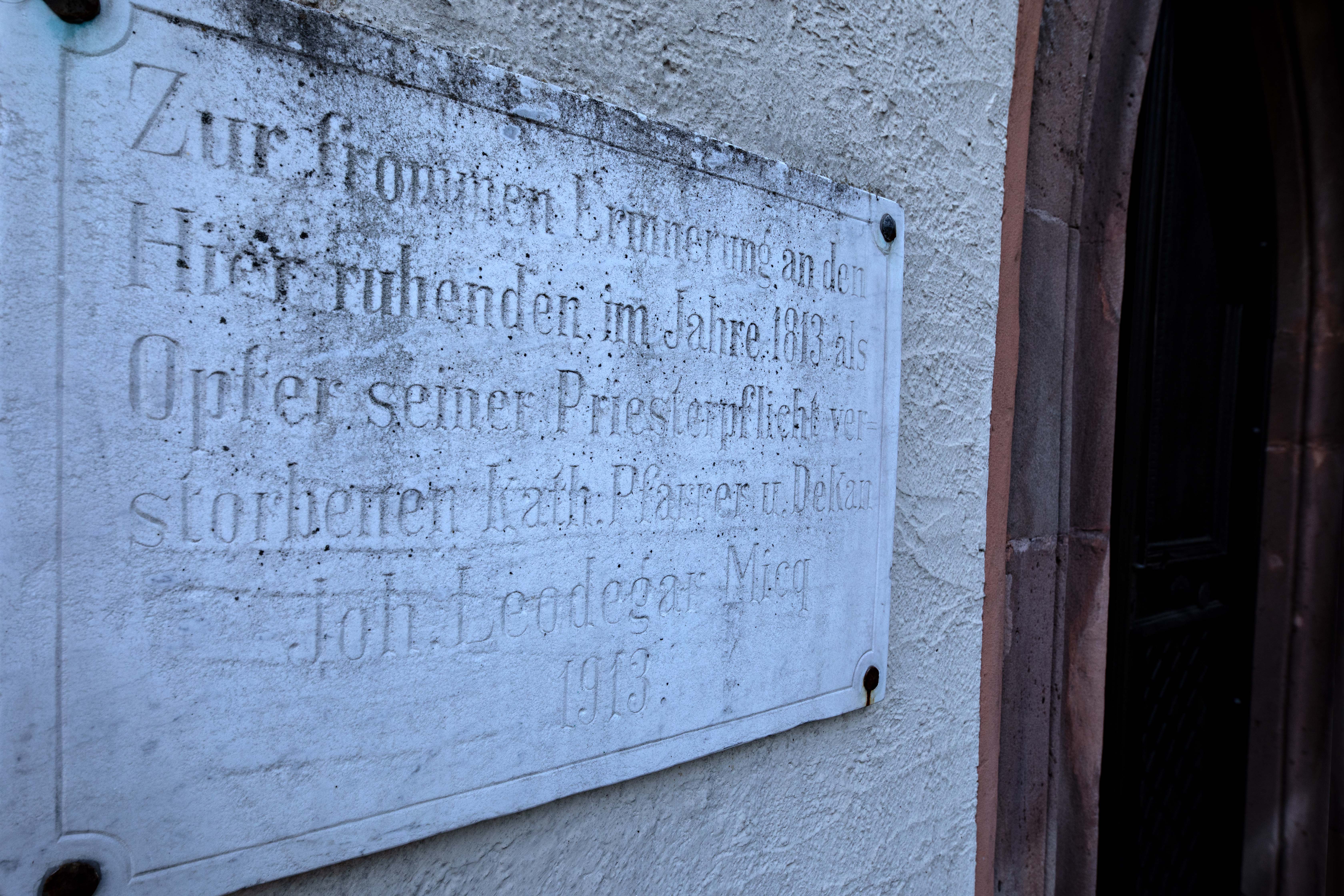 Gedenktafel an den kath. Pfarrer und Dekan Joh. Leodegar Micq neben dem Portal der Alten Kapelle in Landstuhl
