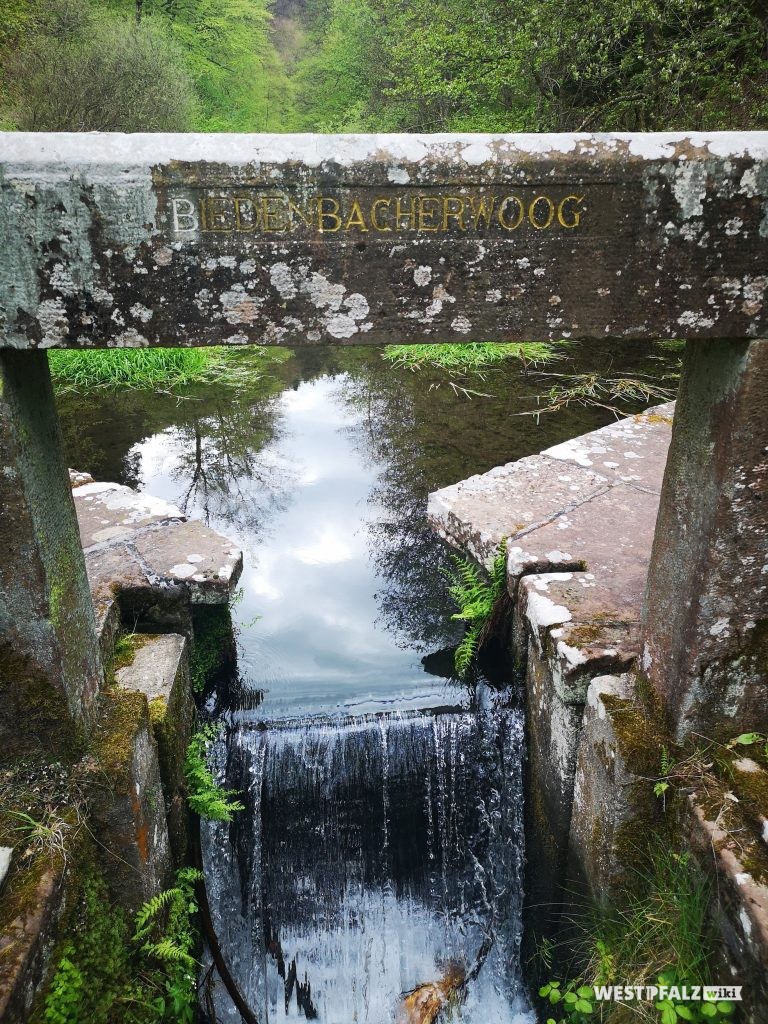 Ritterstein Nr. 156 mit der Inschrift "Biedenbacherwoog" in einem Stein des Wehres am gleichnamigen Woog