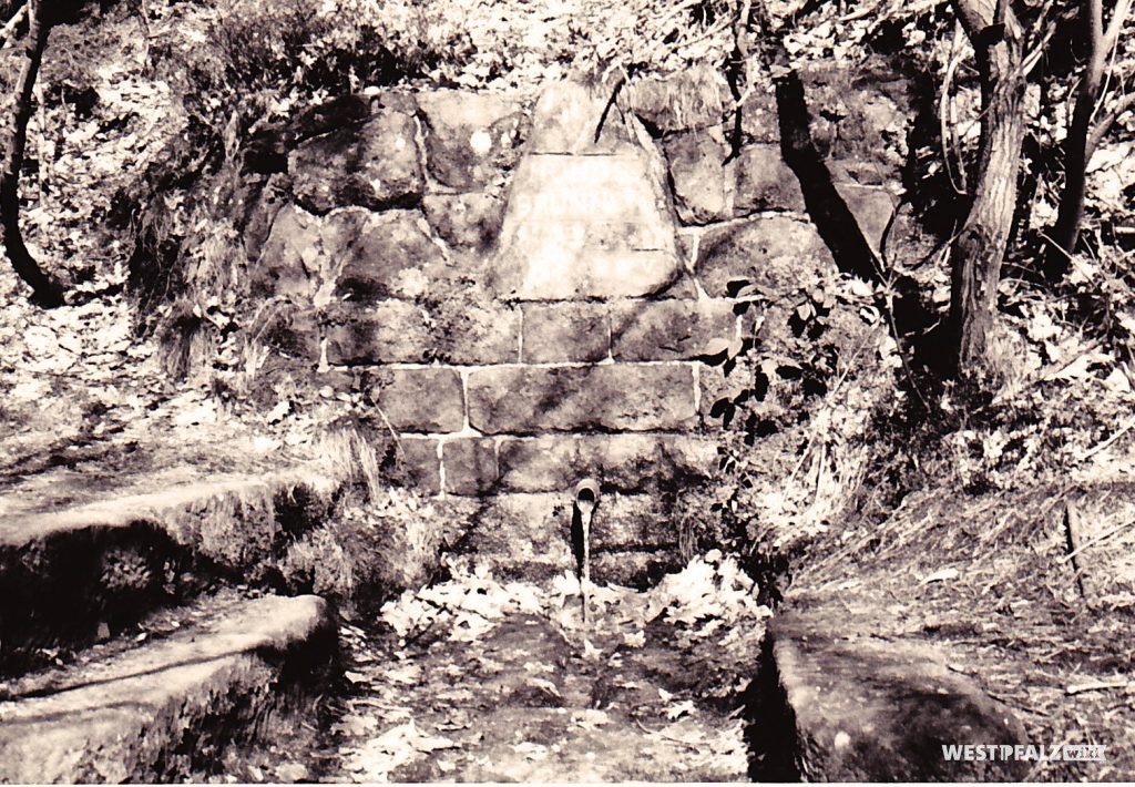 Hundsbrunnen mit dem ins Mauerwerk integrierten Ritterstein mit der Inschrift "Hundsbrunnen" im Hundbrunnertal