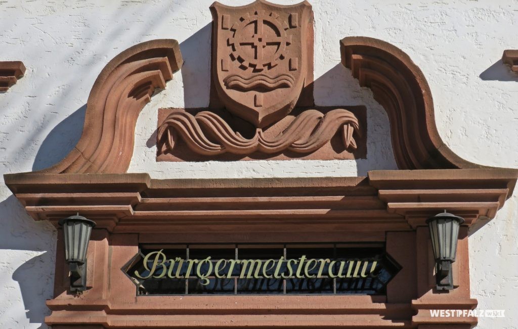 Ortswappen mit Sandsteinfries über der Eingangstür des Rathauses in Erfenbach
