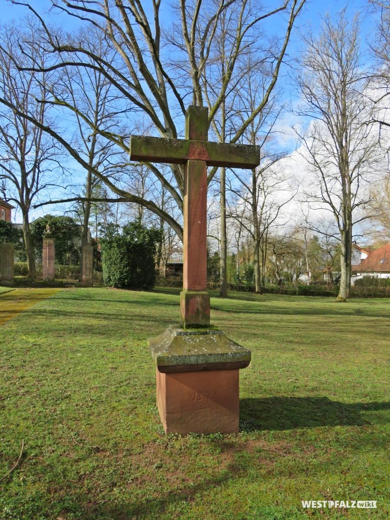 Friedhofskreuz - im Hintergrund das Kriegerdenkmal