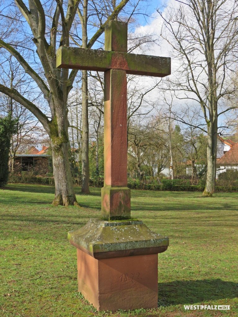 Friedhofskreuz - im Hintergrund das Kriegerdenkmal