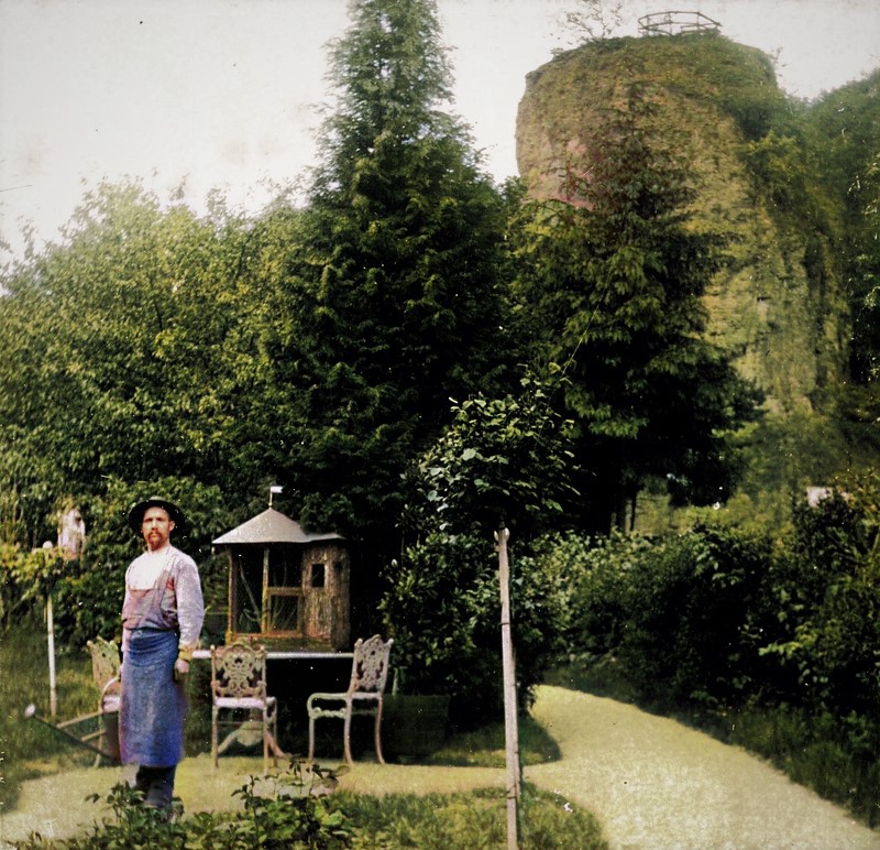 Im Vordergrund ein Gärtner des Herrenhausgartens und im Hintergrund der Aussichtspunkt des Felsengartens