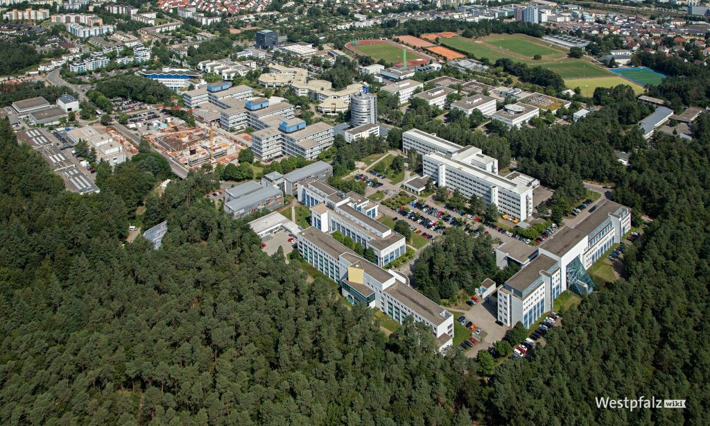 Campus aus östlicher Perspektive. Im Vordergrund die Gebäude der Fachbereiche Chemie und Biologie. Im Hintergrund ist das Sportareal und Teile der Uni-Wohnstadt zu sehen.