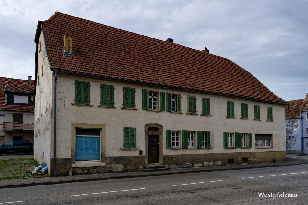 Putzbau mit grünen Fensterläden