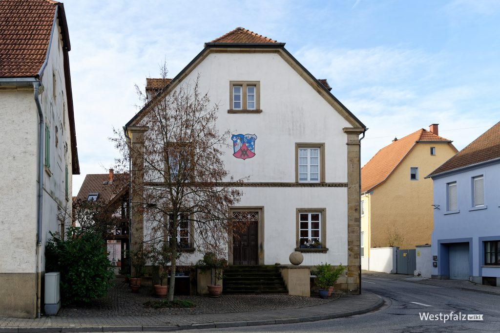 Frontale Ansicht auf den Eingang und das Wappen